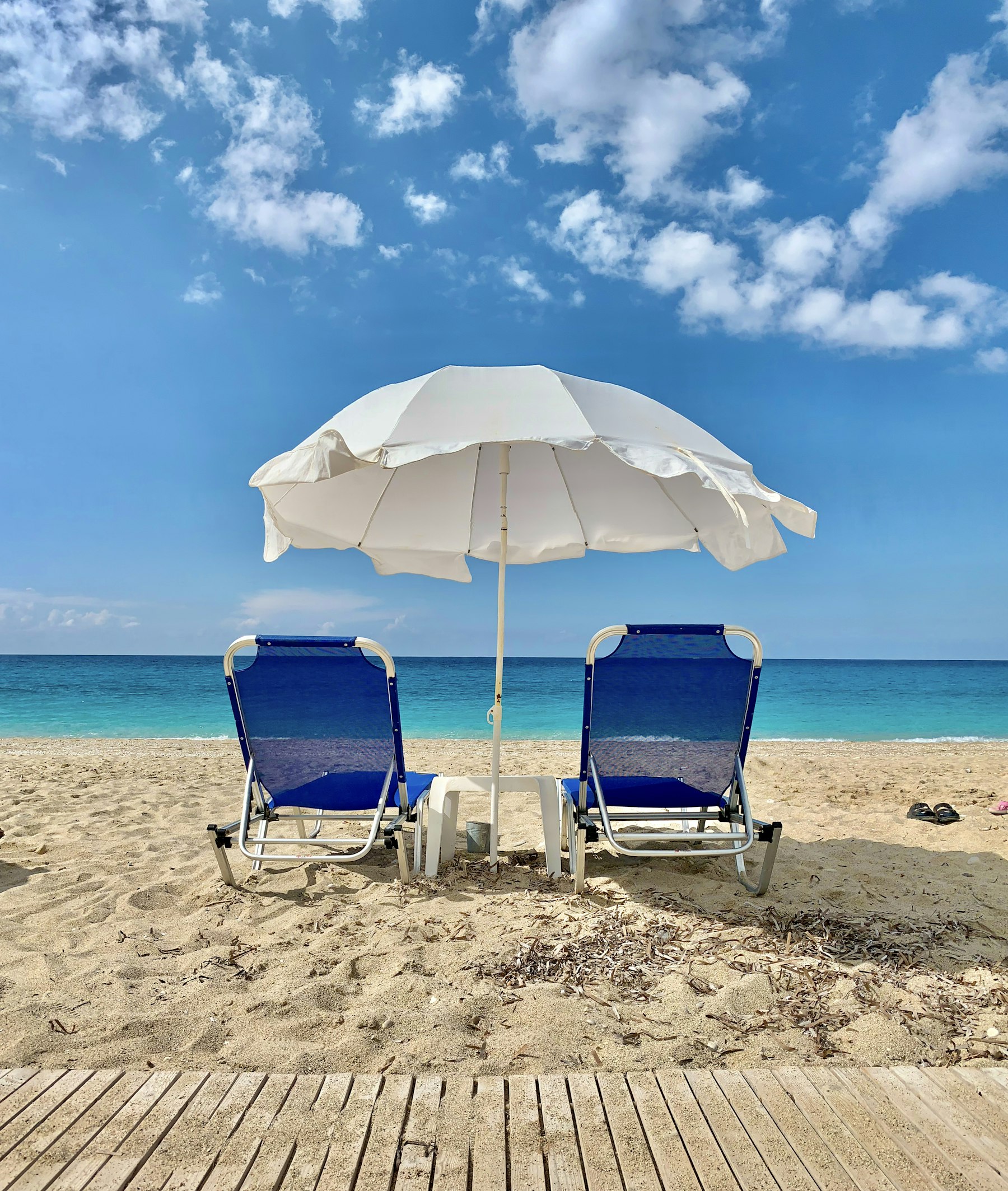 Beach umbrella and chairs set up on the sand